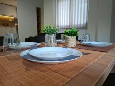 a table with plates and glasses and plants on it at Christina's Home in Athens