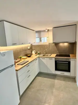 a kitchen with white cabinets and a white refrigerator at Christina's Home in Athens