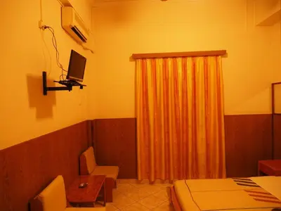 a room with a bed and a television and a table at Aegli Hotel in Athens