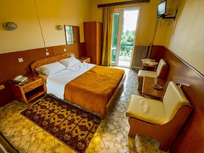 a hotel room with a bed and a chair at Aegli Hotel in Athens