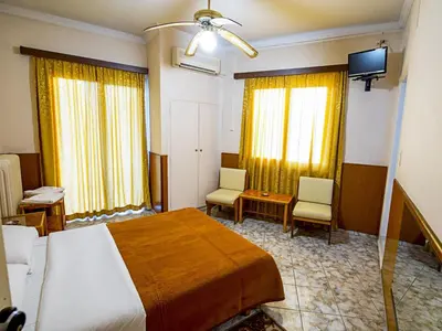 a hotel room with a bed and two chairs at Aegli Hotel in Athens