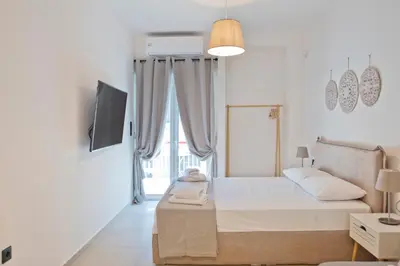 a white bedroom with a bed and a tv at Silia Spotless Fully Renovated Studio in Athens