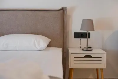 a bed with a white pillow and a lamp on a night stand at Silia Spotless Fully Renovated Studio in Athens