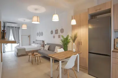 a kitchen and living room with a table and a couch at Silia Spotless Fully Renovated Studio in Athens