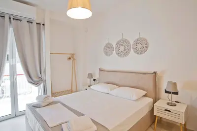 a white bedroom with a bed and a window at Silia Spotless Fully Renovated Studio in Athens
