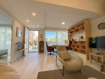 a living room with a couch and a table and a television at Versailles One Garden Villa Full Floor Suite in Koropíon