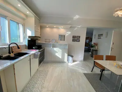 a kitchen with a sink and a table in it at Versailles One Garden Villa Full Floor Suite in Koropíon