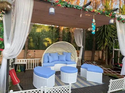 a patio with blue chairs and a gazebo at Versailles One Garden Villa Full Floor Suite in Koropíon