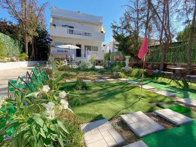 a yard with a house with a red flag at Versailles One Garden Villa Full Floor Suite in Koropíon