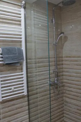a bathroom with a shower with a glass door at Luxury varkiza apartment in Vari