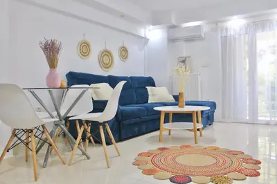 a living room with a blue couch and a table at Luxury varkiza apartment in Vari
