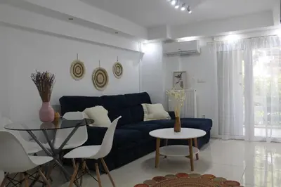 a living room with a blue couch and a table at Luxury varkiza apartment in Vari