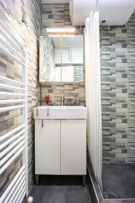 a bathroom with a white sink and a shower at Glyfada Muse - Sea and City Apartment in Athens