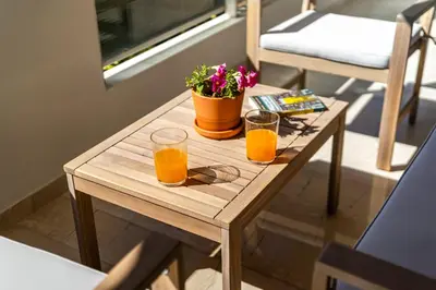 two glasses of orange juice on a wooden table at Glyfada Muse - Sea and City Apartment in Athens