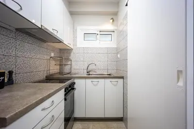 a kitchen with white cabinets and a sink at Glyfada Muse - Sea and City Apartment in Athens
