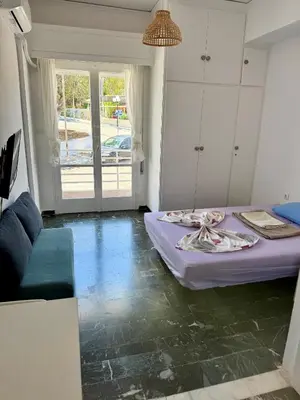 a living room with a bed and a couch at Sunshine Apartment in Palaiá Fókaia
