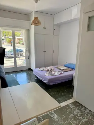 a bedroom with a purple bed in a room at Sunshine Apartment in Palaiá Fókaia