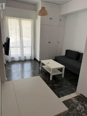 a living room with a couch and a table at Sunshine Apartment in Palaiá Fókaia