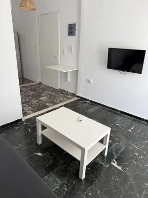 a white coffee table in a room with a tv at Sunshine Apartment in Palaiá Fókaia