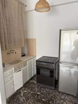 a kitchen with a stove and a refrigerator at Sunshine Apartment in Palaiá Fókaia