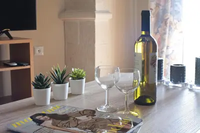 a bottle of wine and two glasses on a table at Ano Patisia, A 5th Floor Fully Renovated Penthouse in Athens
