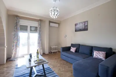 a living room with a blue couch and a table at Ano Patisia, A 5th Floor Fully Renovated Penthouse in Athens