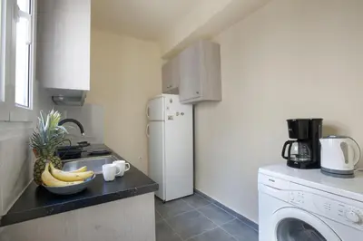 a kitchen with a refrigerator and a bowl of bananas on a counter at Ano Patisia, A 5th Floor Fully Renovated Penthouse in Athens
