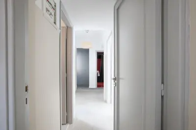a hallway with white walls and an open door at Ano Patisia, A 5th Floor Fully Renovated Penthouse in Athens