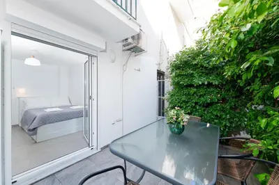 a small balcony with a table and a bed at Maria's Garden in Athens