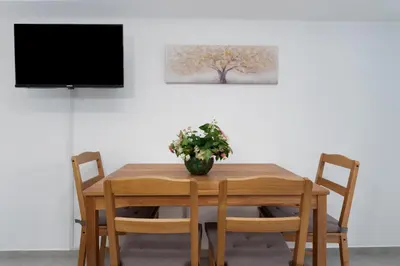 a dining room table with a vase of flowers on it at Maria's Garden in Athens
