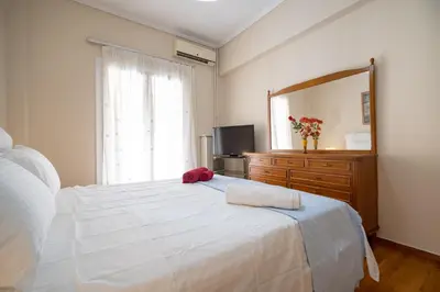 a bedroom with a white bed and a large mirror at Athens Central Charm by ΜΡS in Athens