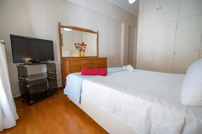 a bedroom with a bed and a flat screen tv at Athens Central Charm by ΜΡS in Athens