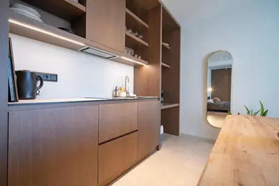 a kitchen with wooden cabinets and a wooden table at Athens Central Skyline Studio by ΜΡS in Athens