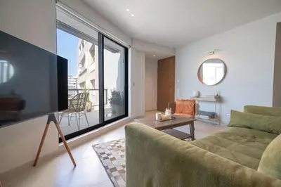 a living room with a couch and a large window at Athens Central Skyline Studio by ΜΡS in Athens