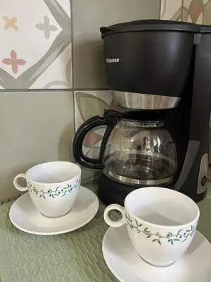 two cups on plates next to a coffee maker at Athenian Loft with urban view! in Athens
