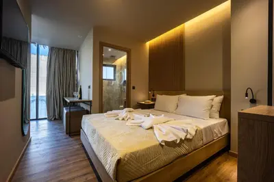 a bedroom with a large bed with white sheets at Bliss Luxury Apartments in Athens