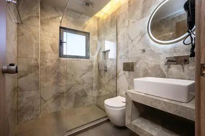a bathroom with a sink and a toilet and a mirror at Bliss Luxury Apartments in Athens