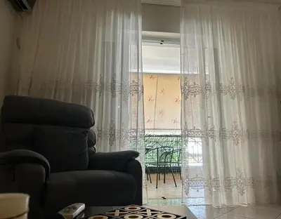 a living room with a chair and a window at Athens Cozy Apartment in Athens