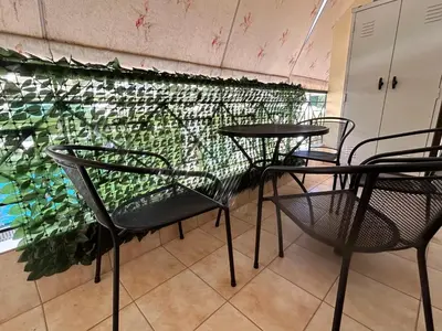 a table and chairs in front of a wall at Athens Cozy Apartment in Athens