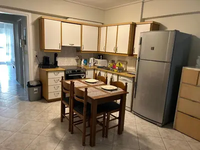 a kitchen with a table with chairs and a refrigerator at Athens Cozy Apartment in Athens