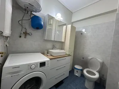 a bathroom with a washing machine and a toilet at Athens Cozy Apartment in Athens