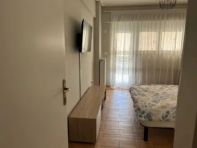 a bedroom with a bed and a table and a window at Athens Cozy Apartment in Athens