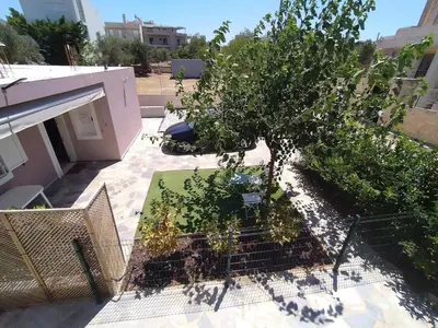a tree in a cage next to a building at Private Little House in Lagonisi in Áyios Nikólaos