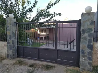 an iron gate with a garden behind it at Private Little House in Lagonisi in Áyios Nikólaos