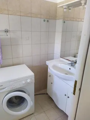 a bathroom with a washing machine and a sink at Private Little House in Lagonisi in Áyios Nikólaos