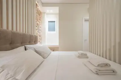 a bedroom with a white bed with towels on it at Stone house in Athens in Athens