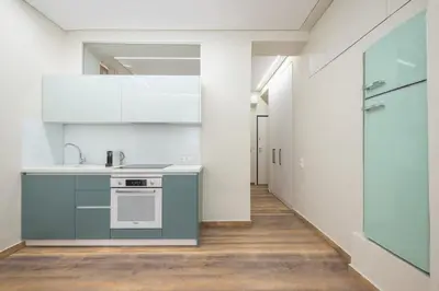 a kitchen with white cabinets and a sink and a hallway at Stone house in Athens in Athens