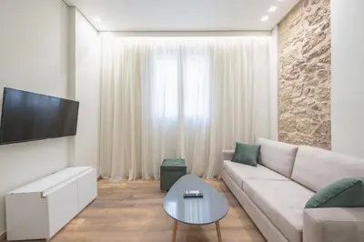 a living room with a couch and a tv at Stone house in Athens in Athens