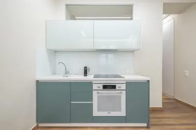 a kitchen with white cabinets and a stove at Stone house in Athens in Athens