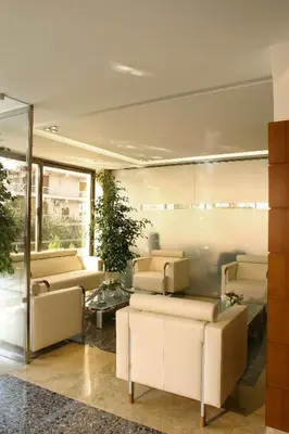 a living room with two couches and a table at Blue Sea Hotel Alimos in Athens